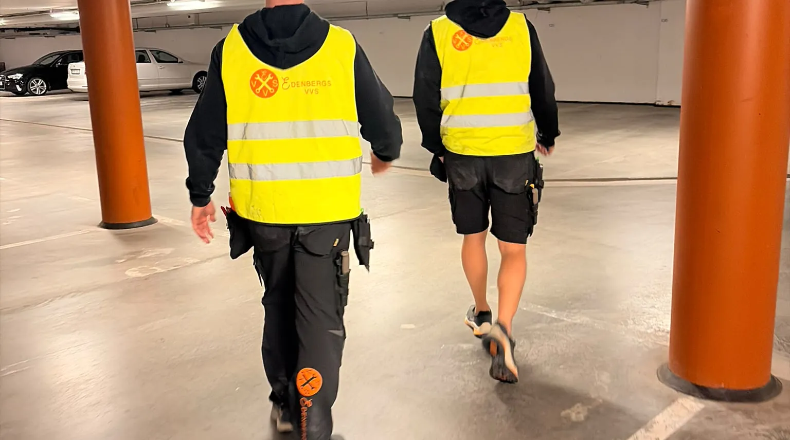 Två montörer från Edenbergs VVS i varselvästar i ett garage